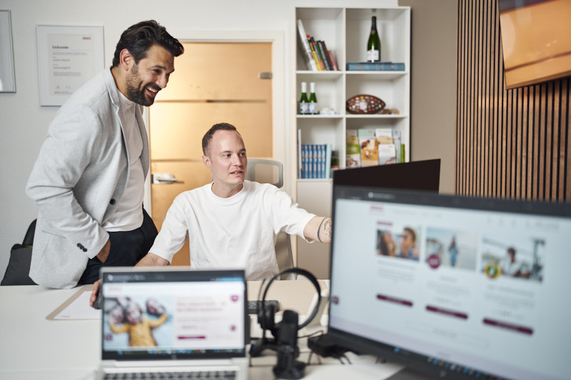 ERGO Mitarbeiter zeigt seinem Kollegen die ERGO Website
