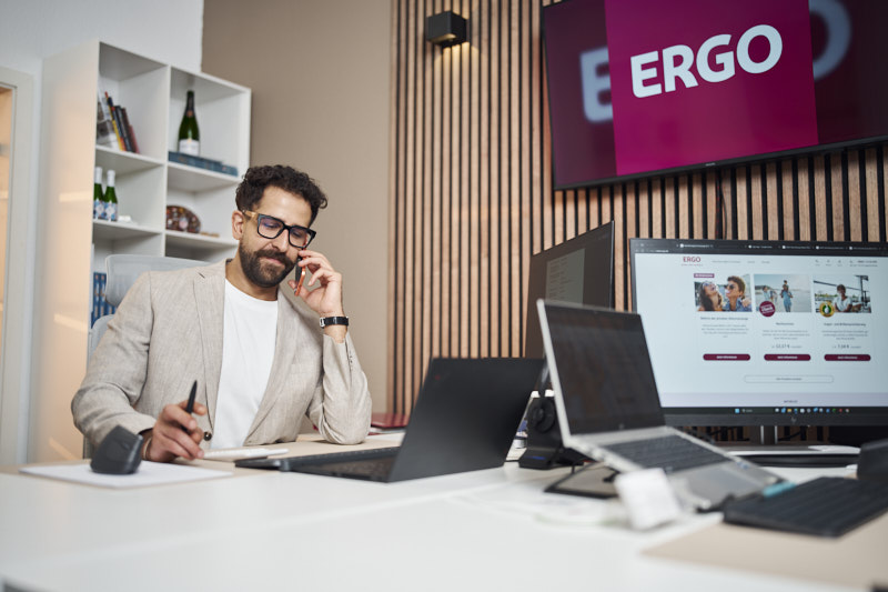 ERGO Mitarbeiter am Arbeitsplatz mit der ERGO Website auf dem Monitor
