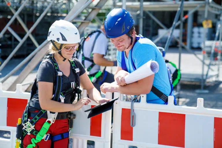 Azubis besprechen Pläne auf der Baustelle
